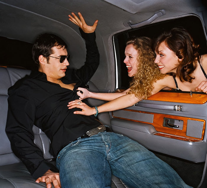 Man in a limo between two women, Arouse-Rx pheromone cologne for men, cedar and citrus